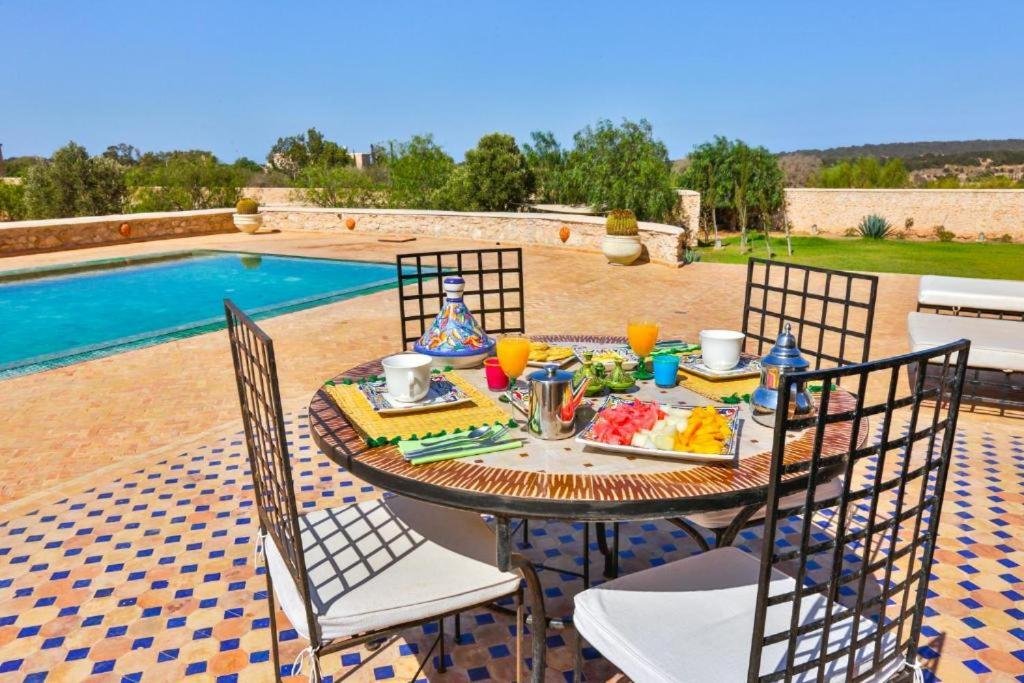 Petit-déjeuner à la carte servi en terrasse au bord de la piscine